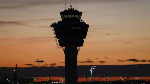 An air traffic control tower at sunset.