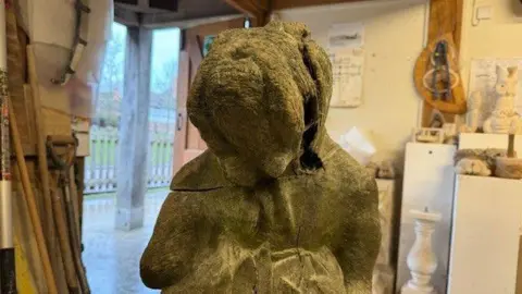 The wooden statue of Dan is badly damaged and his face can no longer be recognised as a bulldog. The wood is cracked and one of his ears is missing.