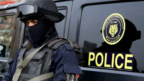 Getty Images An Egyptian policeman stands guard on Cairo's landmark Tahrir Square on 25 January 25