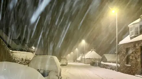 BBC Weather Watchers - Tyke A snowy scene in darkness and thick now on cars and the road