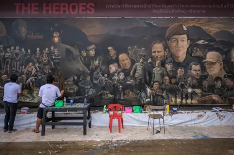 Getty Images Artists work on an art mural at Art Bridge gallery in Chiang Rai, Thailand