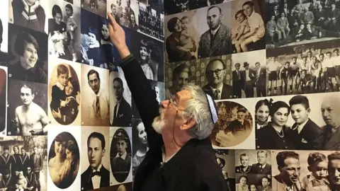 Gyuri Diamantstein pointing to picture of his mother