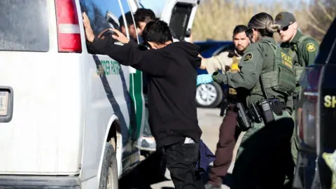 Getty Images Migrant being detained on 4 February