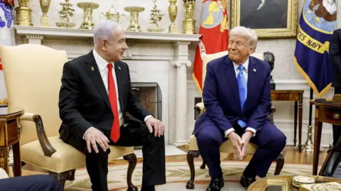 Trump and Netanyahu seated in the Oval Office, smiling at one another 