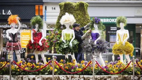 Fabio De Paola/PA Media A florist puts the finishing touches to a floral sculpture depicting the Girls Aloud band in the 2024 Manchester Flower Festival.