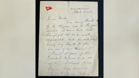 A historic handwritten letter from a passenger on the Titanic. The letter is dated April 10 1912 with a letterhead that says "On board RMS Titanic". There is also a red flag with a white star on the letterhead.