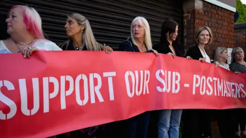A group of sub-postmasters outside a court