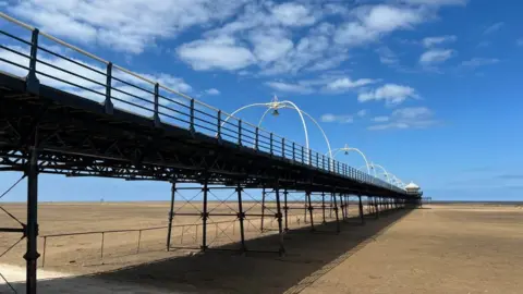 The Southport pier extends out along the beach. 