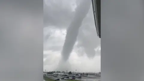 A tornado above a car park.