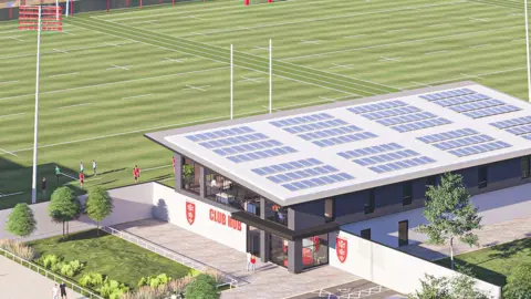 Hull KR An artist impression of building with large windows and a flat roof covered in solar panels. The building sits beside green rugby training pitches marked with white lines and tall goalposts.