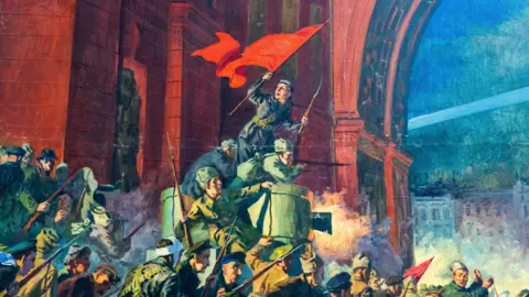 Wotton Auction Rooms A painting showing soldiers, one holding a large red flag, beneath a red-coloured building and archway, in the midst of action.