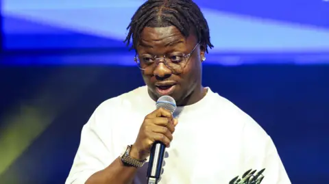 Getty Images Michael Adex on stage after winning the award for Industry Icon during the Nordoff and Robbins Northern Music Awards at The Albert Hall in Manchester in 2024