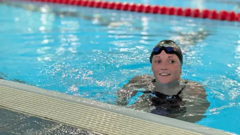 Susannah Hext berenang di kolam renang dengan mengenakan topi renang dan Google Glass di kepalanya