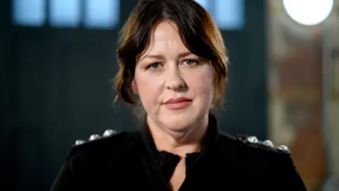 A woman, wearing police uniform, poses for a headshot.