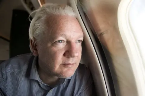 Reuters Julian Assange looking out of a plane window
