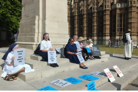 Sisters of Nazareth sit outside Westminster Abbey