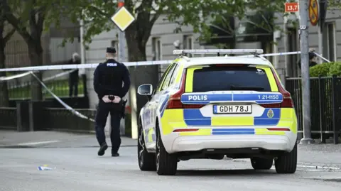 Swedish officer walks near police car