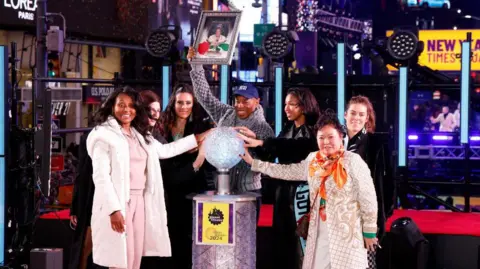 Getty Images Tracey Collins, Eric Adams y miembros del Gotham FC esperan a que caiga la bola durante la víspera de Año Nuevo en Times Square