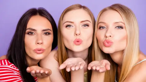 Women kissing and blowing with open-hand gesture