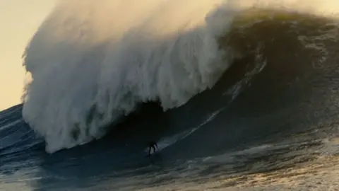 Huge wave with a surfer riding it
