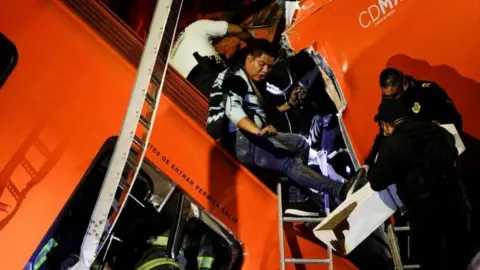 Reuters Rescuers search for survivors at a crash site in Mexico City, Mexico. Photo: 4 May 2021