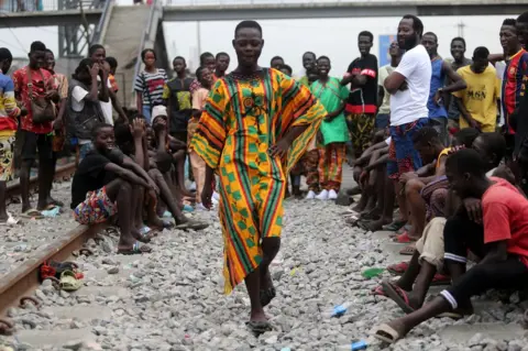EPA Children and young people smile, laugh and look around as they take part in a fashion show.