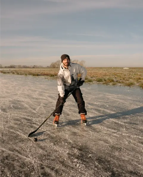 Harry George Hall Max, an ice hockey player, prepares for some practice on the frozen fen