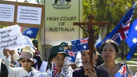 EPA Supporters of George Pell carry crosses and signs outside the High Court of Australia during his appeal hearing