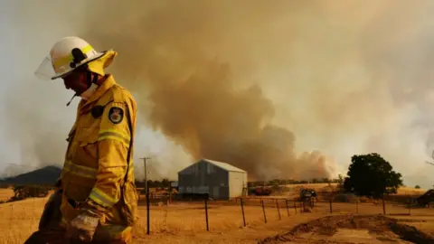 Getty Images A Rural Fire Service firefighter views a flank of a fire on 11 January, 2020 in Tumburumba, Australia