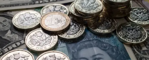 Getty Images Pound coins and dollars