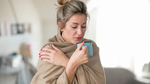 Getty Images Woman wrapped in blanket