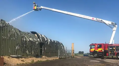 Cambridgeshire Fire and Rescue Service Firefighter uses water jet to tackle fire at Corkers Crisps