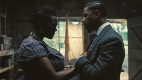 Warner Bros Wunmi Mosaku y Michael B. Jordan en Sinners