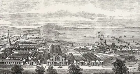 Getty Images An artists impression of Melbourne in the 1800s. A large landscape sketch with various buildings by the sea. There are boats in the water and mountains in the background.