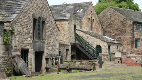 Stone industrial buildings with a staircase and grinding wheels