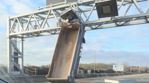 Image of a lorry bed wedged under an overhead gantry on M5