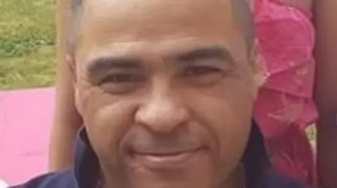 A close up of Marc Allen who is a man in middle age. He has grey hair and is smiling in the photo. 