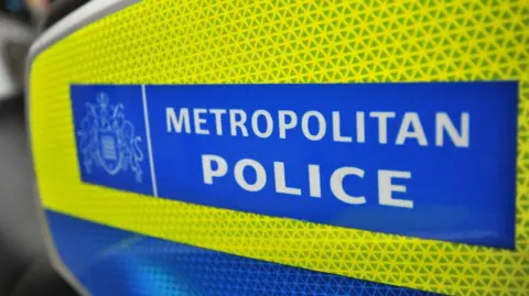 A yellow and blue sign containing the white words "METROPOLITAN POLICE"