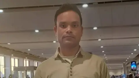Masood Alam, one of the seafarers who returned on 29 March, wearing a tee shirt, pose for a photo.