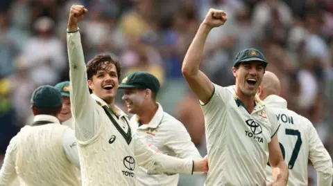 Sam Konstas (left) and Pat Cummins celebrate the fourth Test win over India