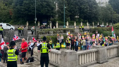 BBC Anti-racism campaigners, to the right of the picture, facing anti-immigration protesters, to the left of the picture, with police surrounding them close to the Cenotaph 