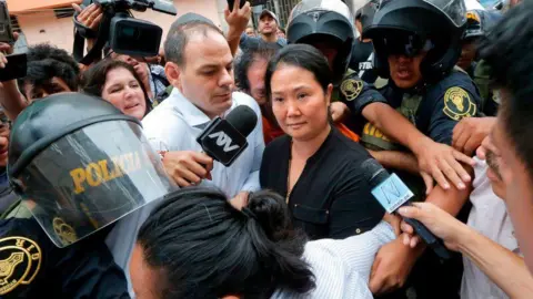 AFP Peruvian politician Keiko Fujimori (right) arrives in a courtroom in Lima on January 20, 2020, accompanied by her husband Mark Villanella.