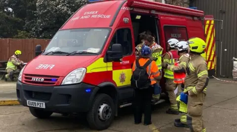 Essex County Fire and Rescue Service Fire fighters at a red incident support van. 