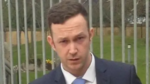 BBC  Shows Cormac McGuckin in a dark suit and tie