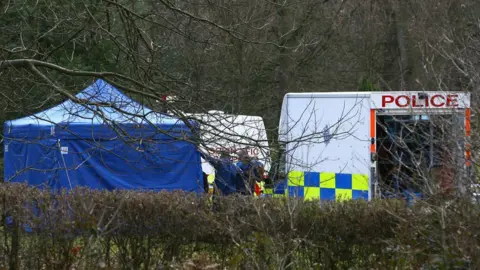 PA Media Police forensic officers in Haywards Heath Cemetery