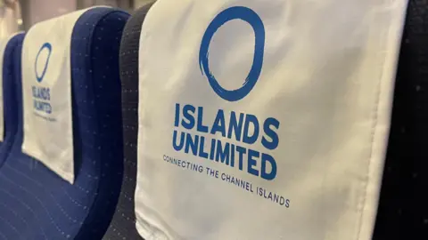 A close-up of the Islands Unlimited logo draped over a seat on the boat.