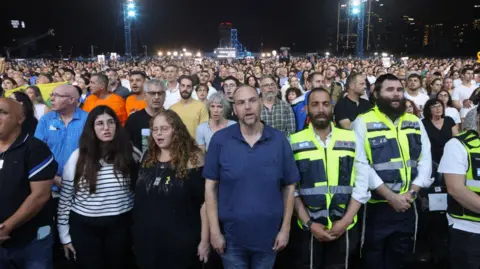 Reuters People sing as they take part in an alternative memorial ceremony organized by the families of hostages held in Gaza