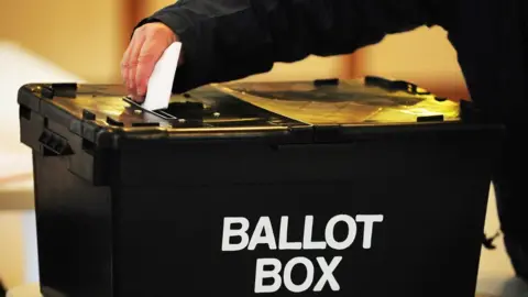 A man places a ballot into a ballot box