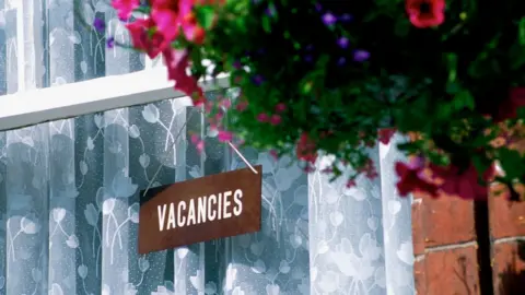 Getty Images Vacancies sign in hotel window