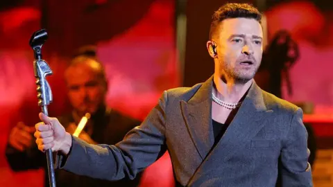 Reuters Justin Timberlake performing on stage, holding a microphone stand 